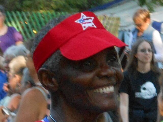 Mary Sims smiling and wearing a red baseball cap