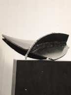 Curved abstract metal fragment on display in art show