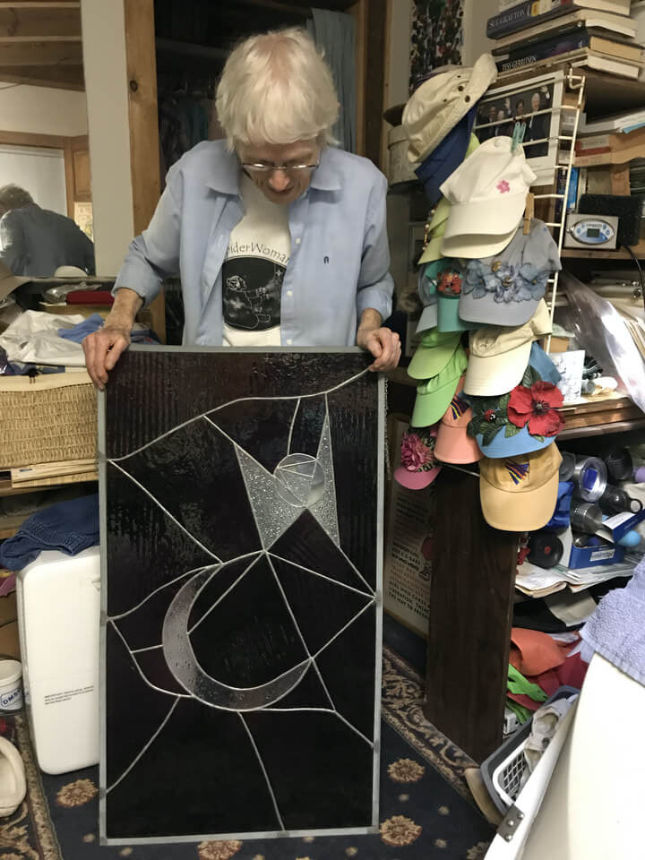 Ellen Spangler holding a 3 foot glass with a crescent moon and stylized star