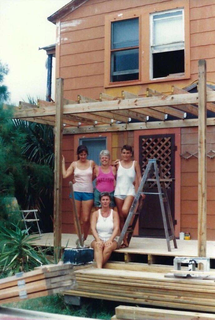 standing left to right Karen Jones, Rainbow Williams, Martine Giguère with Jean Francis seated all on a deck they’re building