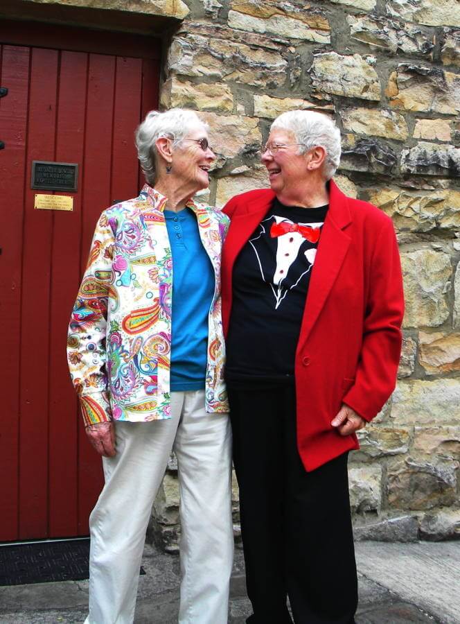 Ellen Spangler and Mary Alice Stout standing with an arm around each other smiling happily into each other's eyes