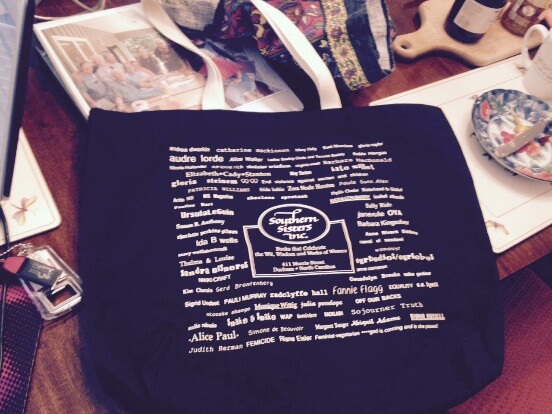 Black tote bag with white text with names of women writers and Southern Sisters logo