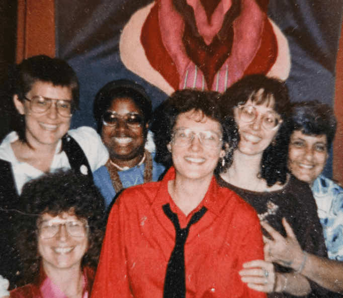 Terri Jewell with five other Louisville Kentucky poets pose in front of a vulva painting