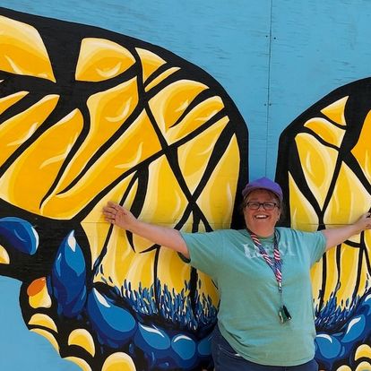 Gareth Fenley standing in front of large painting of butterfly.