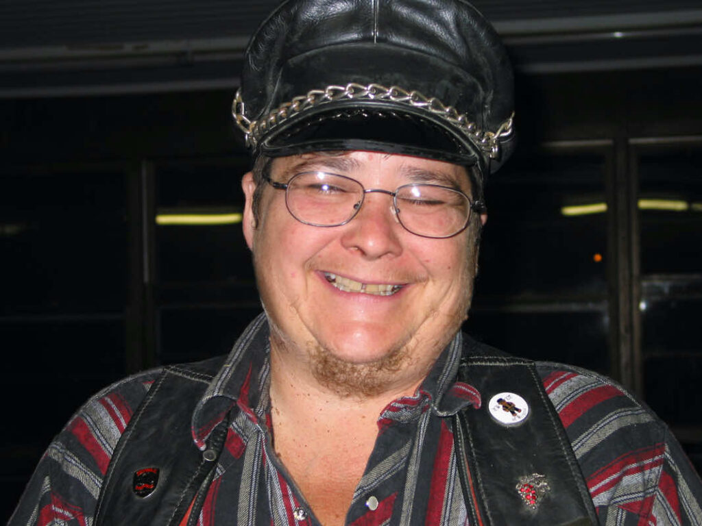 Cherry Omega wearing leather hat and leather vest