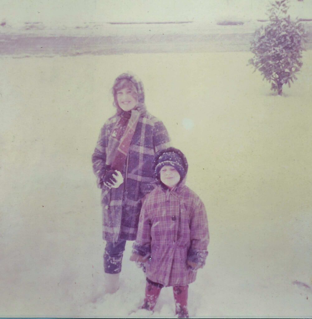 Lenny Lasater age 12 stands bundled up in snow younger brother Kevin in from