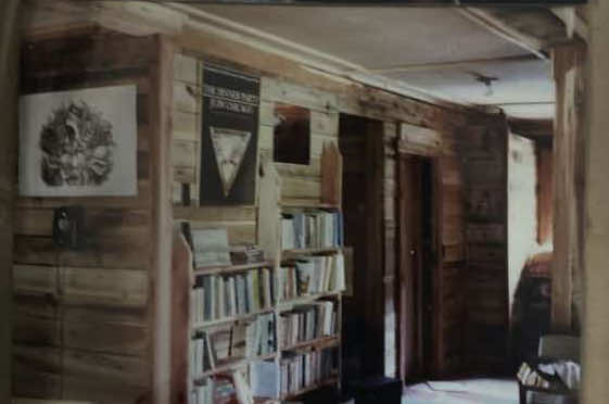 Upstairs hallway sowhs wood wall and full book shelves of Merril Mushrooms home