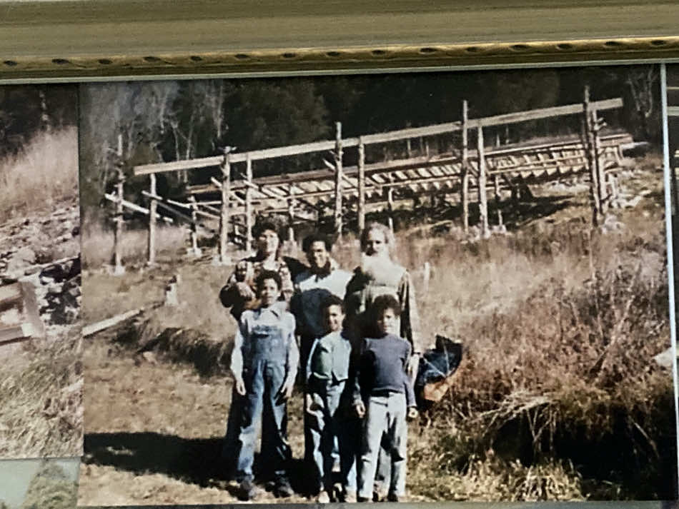 Merril Mushroom, Jaime, and Gabby in back row and Scott, Ananda, and David in front row with house under construction behind them