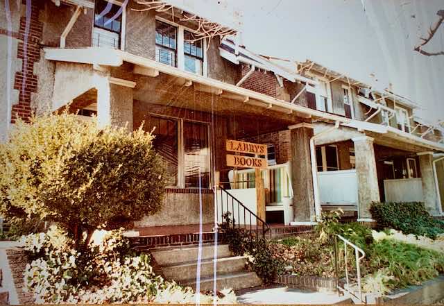 Two-story brick houses with front porches, close together, bookstore sign on porch