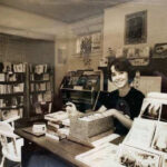 Terri Barry Labrys at desk smiling crop OPT