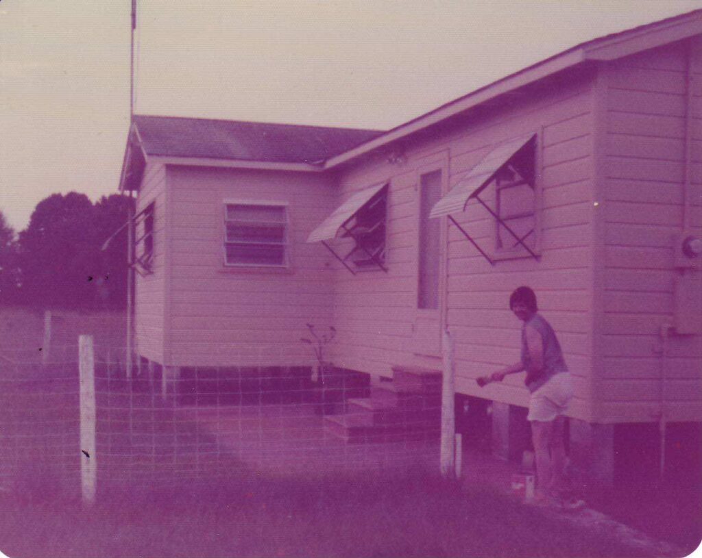 Shewolf painting exterior of farm house at Womanworld