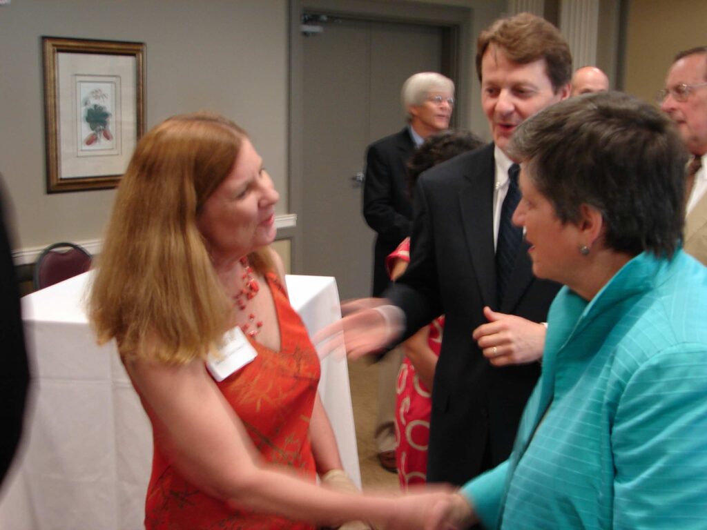 Marie Steinwachs shakes hands with Janet Napolitano left to right with unknown man in background