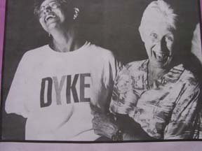 Two women laughing, one wearing tshirt with DYKE on the front