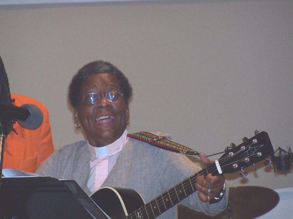 Carolyn Mobley-Bowie is singing and playing a guitar