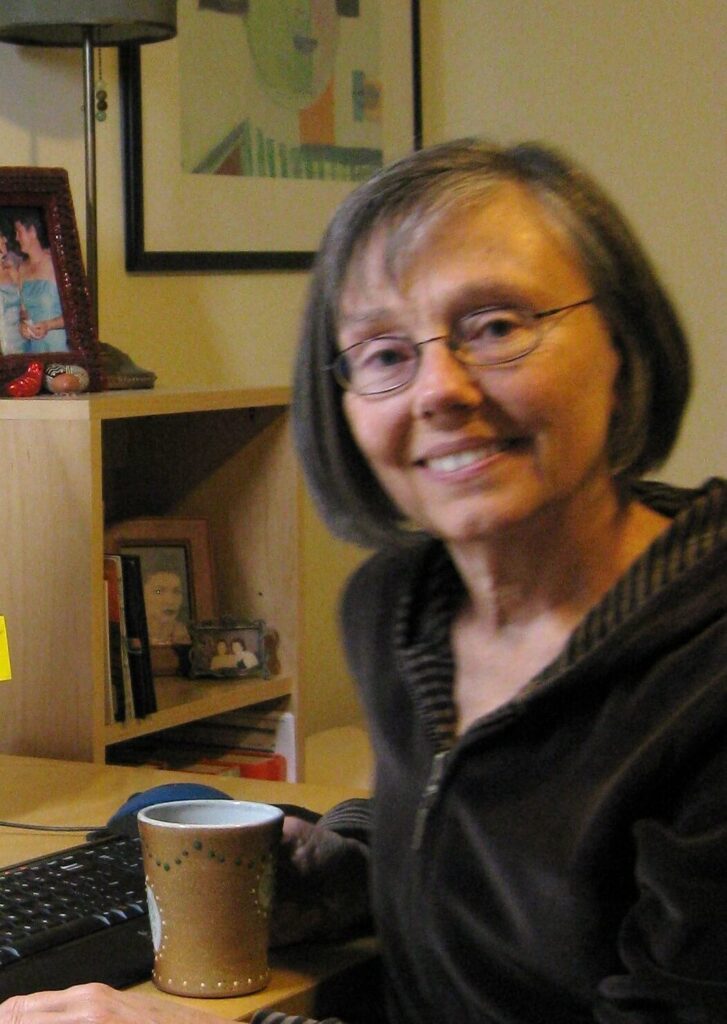 Laurel Ferejohn seated facing the camera holding a coffee mug