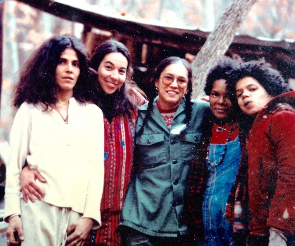 five women with arms around each other. left to right, Clary-Perez-Marsha-Gomez-Burning-Cloud-Sheila-Isis-Brown