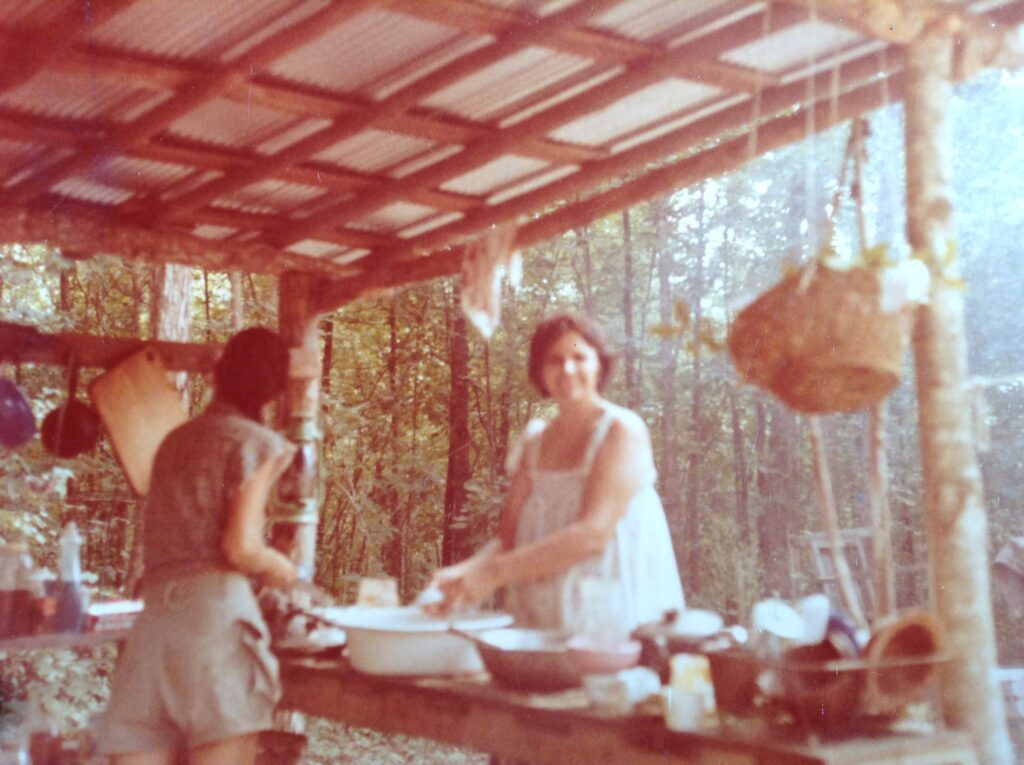 SunHawk and her mother working in outdoor kitchen.