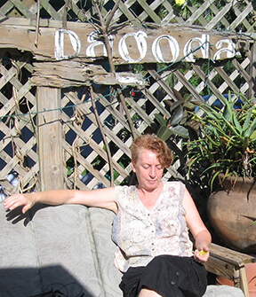 Myriam is seated outdoors on a couch under a Pagoda sign.