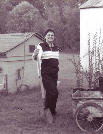 Shewolf standing with a shovel between two houses on her land woman world in 1991