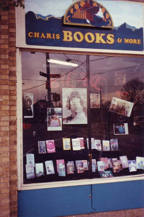 display of books and photos in window under Charis Books and More sign