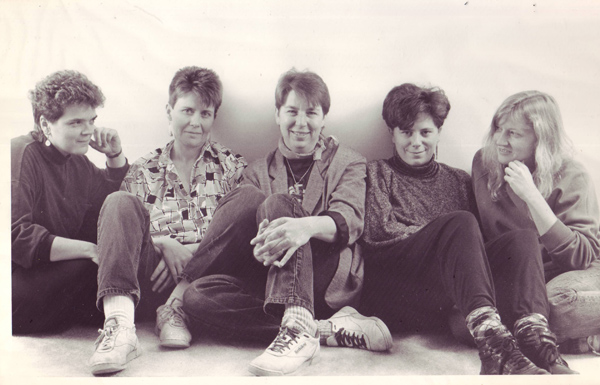 In this studio portrait, the band members are sitting on the floor, wearing jeans and other informal slacks.